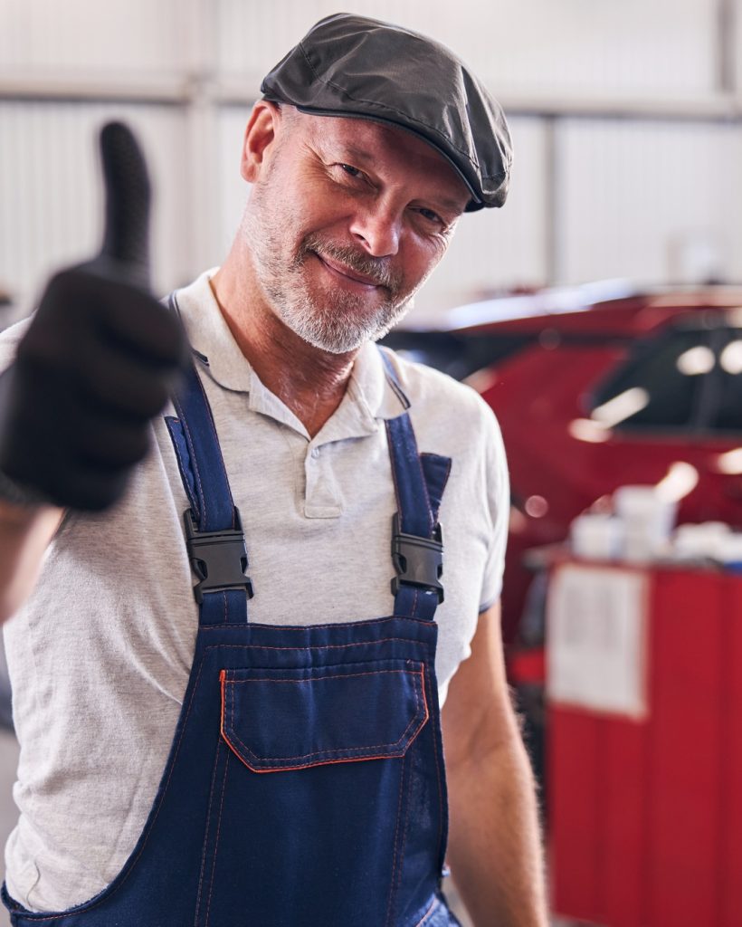 Handsome mechanic giving thumbs up and smiling